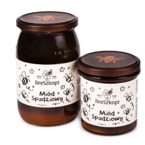 Dwa słoiki miodu spadziowego marki BeeSzkopt o różnych gramaturach na białym tle