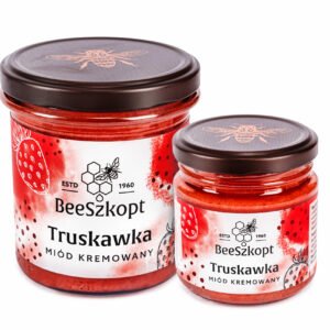 Dwa słoiki miodu kremowanego z truskawką marki BeeSzkopt o różnych gramaturach na białym tle