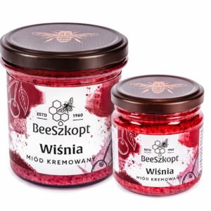 Dwa słoiki miodu kremowanego z wiśnią marki BeeSzkopt o różnych gramaturach na białym tle