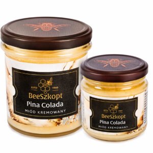 Dwa słoiki miodu kremowanego Pina Colada marki BeeSzkopt o różnych gramaturach na białym tle