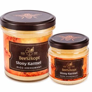 Dwa słoiki miodu Słony Karmel marki BeeSzkopt o różnych gramaturach na białym tle
